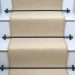 Baileys Herringbone Stair Runner on a staircase with rods.