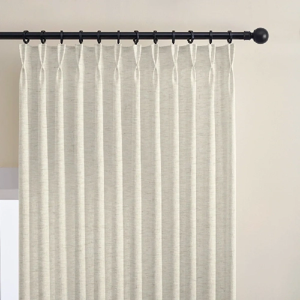 Close-up of a single off-white double pinch pleat linen curtain