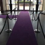 Deep purple carpet runner leading toward glass doors