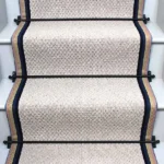 French Grey Small Boucle Wool Stair Runner with black stair rods and a stripe border.
