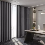 Full-length gray wave fold blackout curtain in a modern office