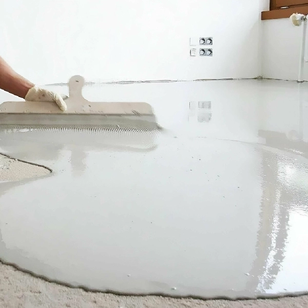 Hand applying white self-leveling epoxy coating on floor