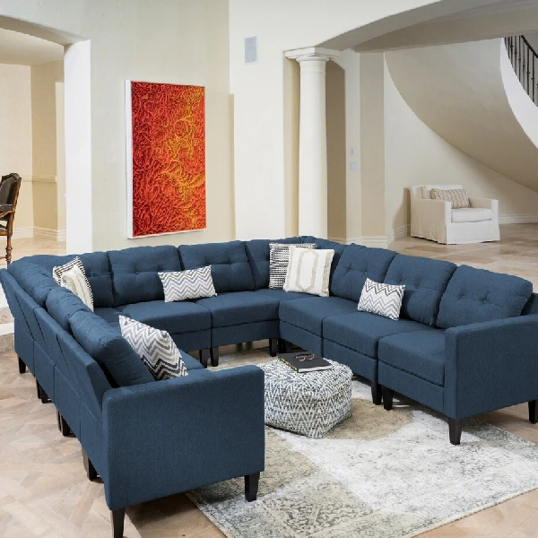 Large U-shaped modular sectional sofa in navy blue fabric with decorative throw pillows