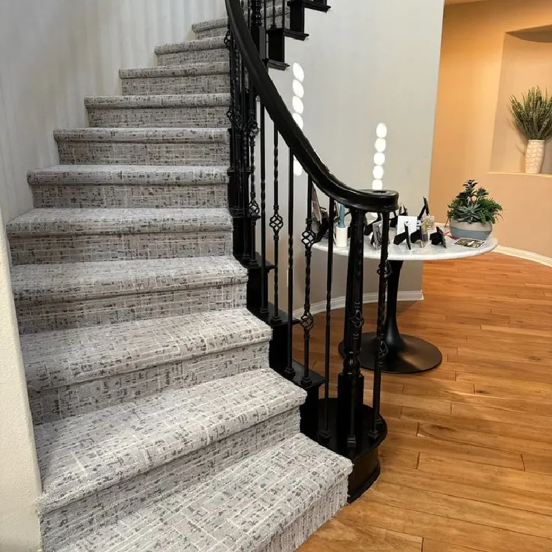 Light gray patterned stair runner with black wrought iron railing