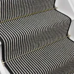 Magpie striped stair runner with black and white stripes and brass stair rods.