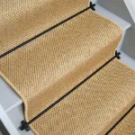 Natural mini basketweave sisal stair runner with black edging and black stair rods.