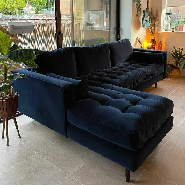 Navy blue velvet L-shaped sectional sofa with a tufted chaise lounge