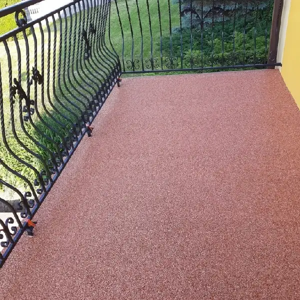 Outdoor balcony floor covered in a reddish-brown textured rubber