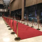 Red carpet entrance lined with gold stanchions