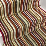 Strata wool striped stair runner with multicolored stripes and brass stair rods.