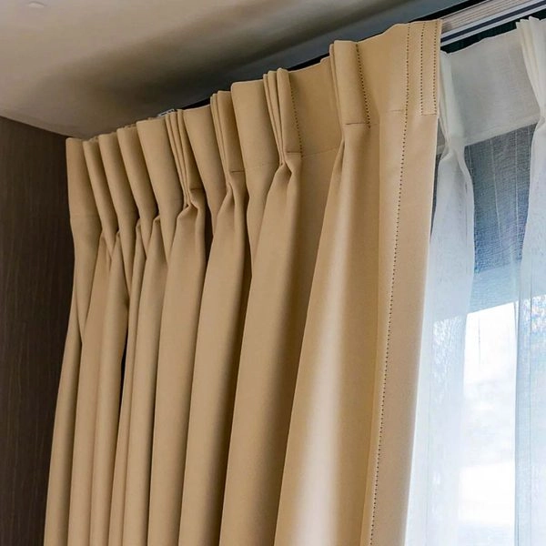 Taupe triple pinch pleat curtain on a motorized track