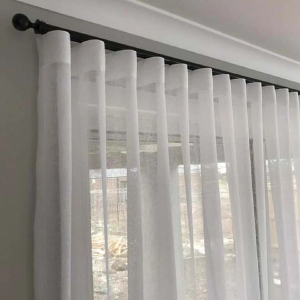 White sheer S-fold motorized curtain on a dark track