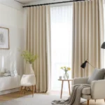 beige blackout curtains layered over sheer white curtains