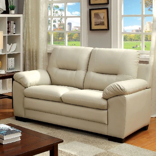 beige faux leather loveseat with rolled arms and plump cushions