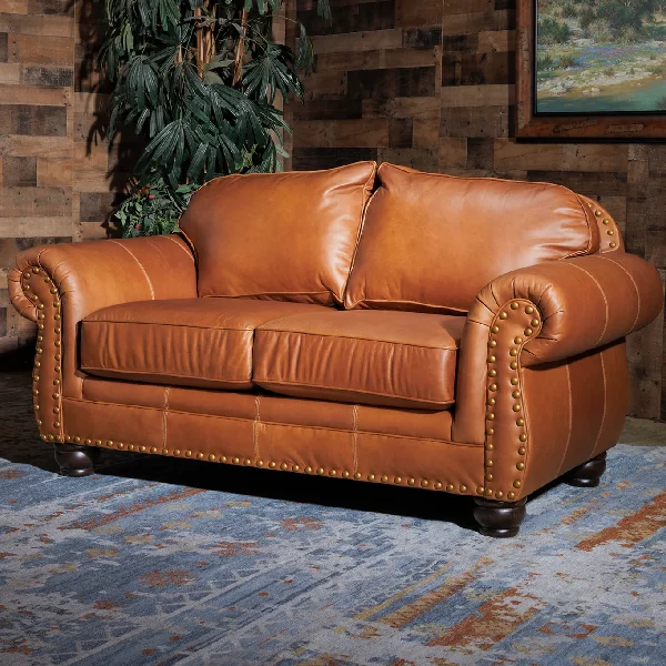 brown leather love seat with a studded trim along the bottom and arms
