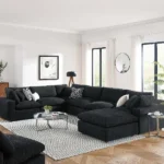 dark charcoal custom U-shaped modular sofa with white accent pillows