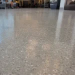 light gray concrete floor with visible aggregate, finished with a clear epoxy coating
