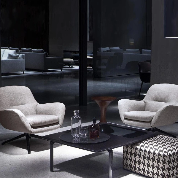modern armchairs flank a dark coffee table with a decanter and glasses
