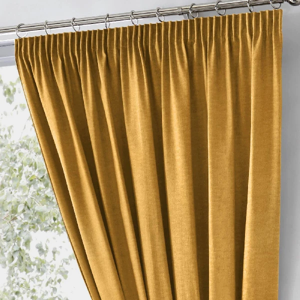 mustard yellow pencil pleat blackout curtain on a track