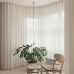 neutral sheer curtains covering a wall of windows