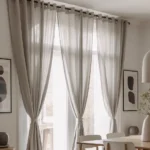 sheer light beige grommet curtains tied back in the middle