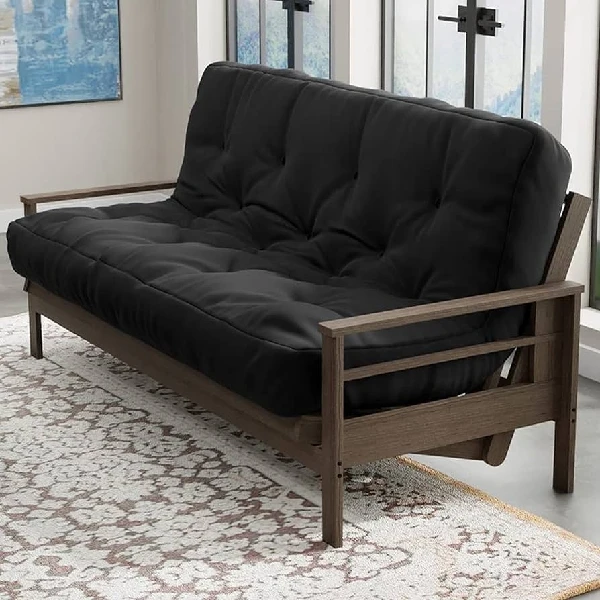 Black tufted futon mattress on a brown wood frame sofa