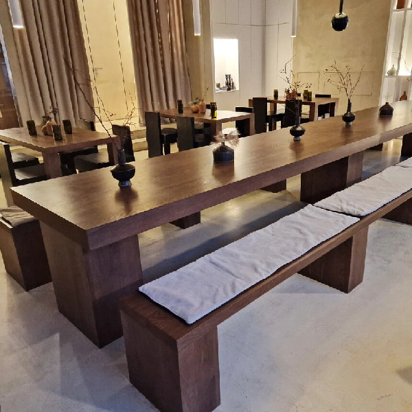 Long wooden custom communal dining table with a matching bench