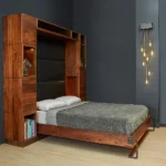 Modern dark-wood Murphy bed lowered into a bedroom with a dark gray wall