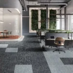 Modular carpet tiles in patterns of black, dark gray, and light blue, laid out in a modern office