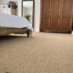 Natural beige sisal carpet in herringbone pattern in bedroom