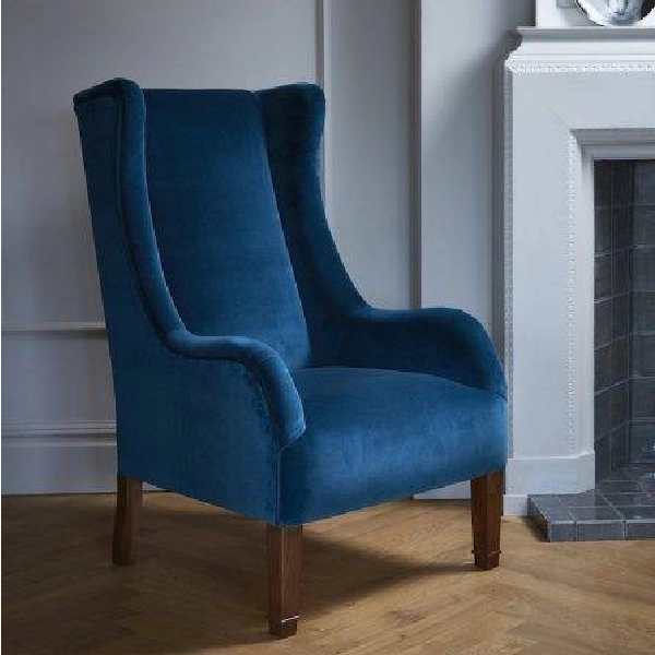 Tall blue velvet wingback armchair with wooden legs