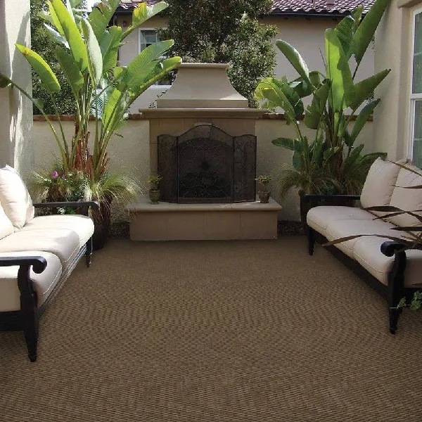 Tan and brown woven outdoor rug covering a patio area