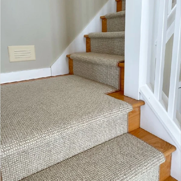 Wool carpet runner on light wood stairs.
