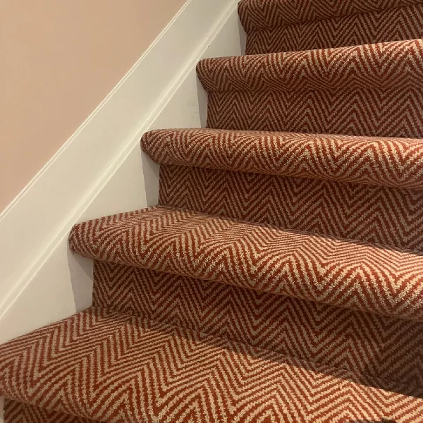 beige chevron-patterned carpet runner on stairs.
