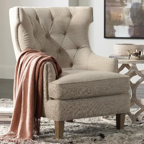 beige tufted wingback armchair with nailhead trim