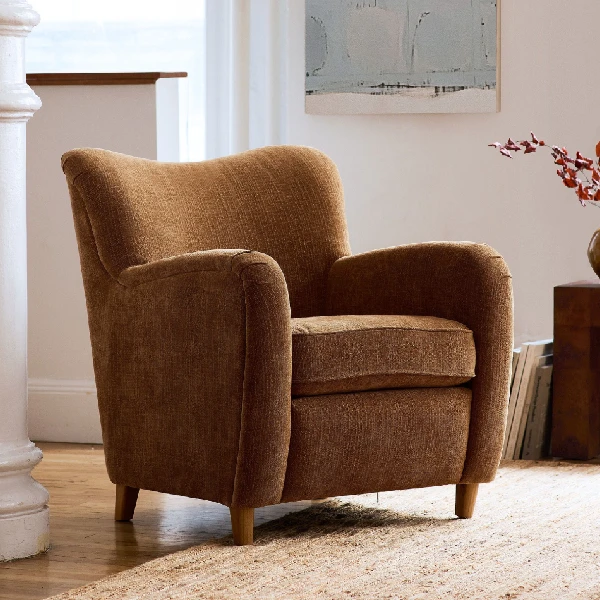 brown upholstered armchair with rounded arms