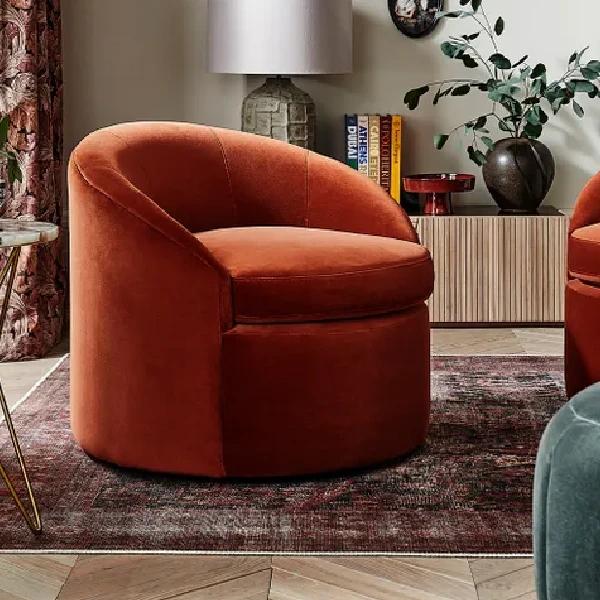 rust-colored velvet accent chair with a swivel base.