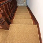 sisal stair runner in a light brown color installed on wooden stairs