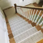 textured stair runner with a subtle grid pattern installed on polished natural wood stairs