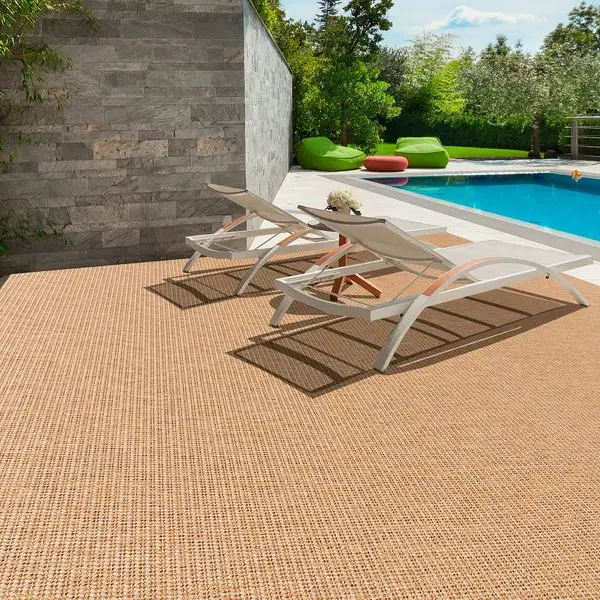 woven outdoor rug in a natural tan color next to a poolside patio area